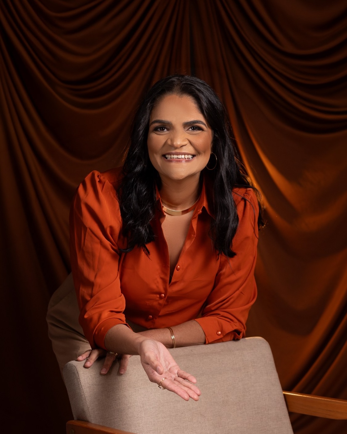 Nilça Feitosa, escritora e mentora, sorrindo em retrato de estúdio